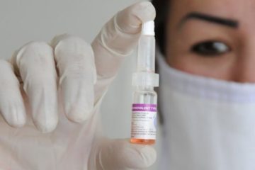 врач в руке держит вакцину